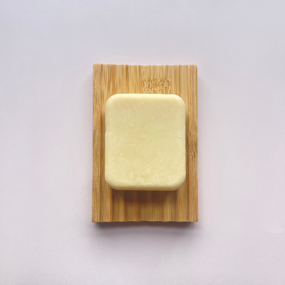 Single bamboo soap dish with our oatmeal and honey soap bar on top to showcase the product in use.