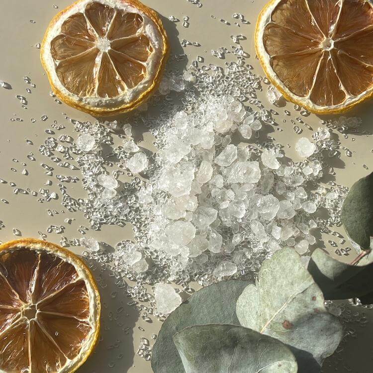 Detox magnesium bath salts product scattered on a beige background.