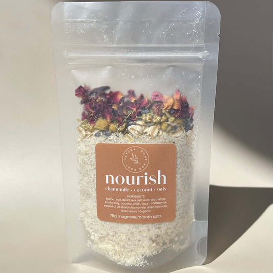 75g 'nourish' magnesium bath salts on display on a coloured background with the sun as natural lighting.