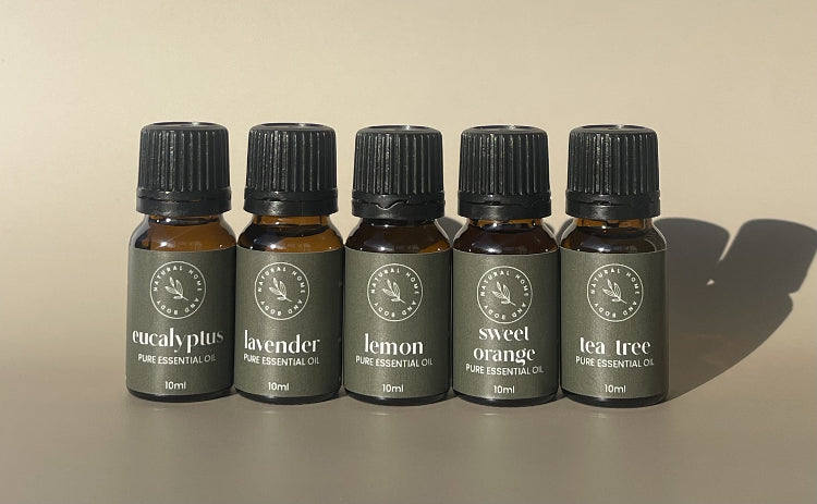 Five bottles of essential oils with labels on a beige background