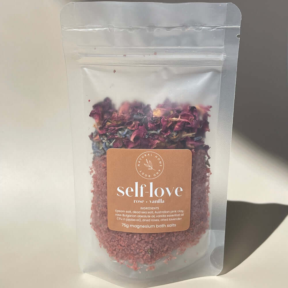 75g 'self love' magnesium bath salts on display on a coloured background with the sun as natural lighting.