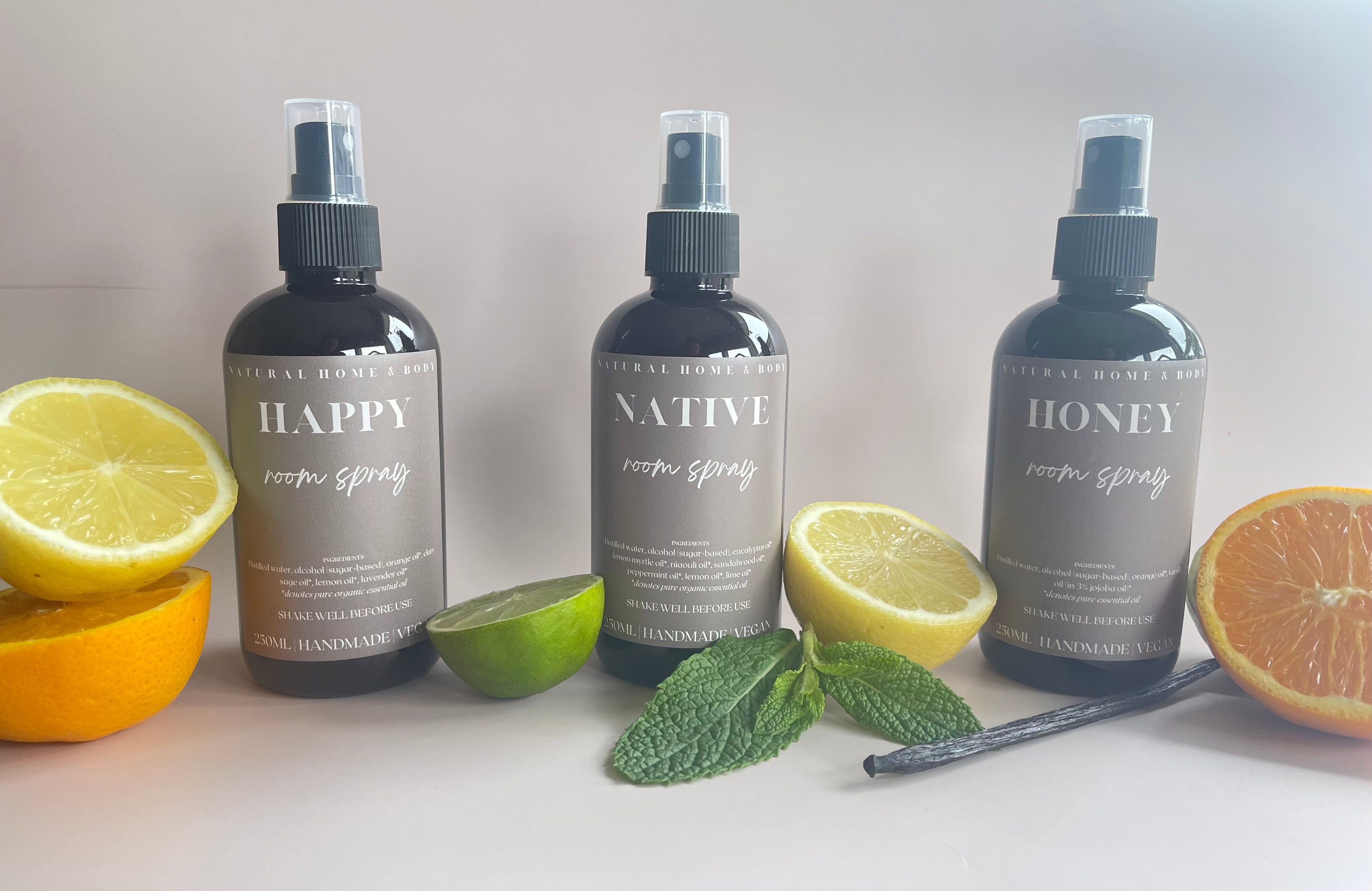 Our natural room and linen sprays are crafted using pure essentials oils. Our three scents are lined up with freshly cut lemons, oranges, mint and a vanilla stick to showcase their scents.