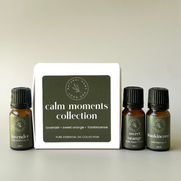 'Calm Moments Collection' trio essential oil box, with essential oil bottles labelled 'lavender' 'sweet orange' and 'frankincense' next to the box. All with dark green product labels.