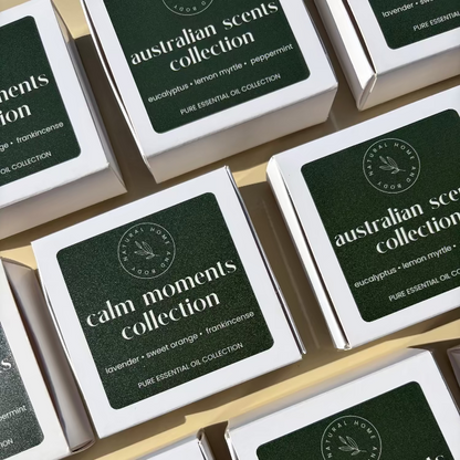 Boxed trio essential oil collections called 'calm moments collection' and 'australian scents collection', with dark green labels across a beige coloured background.