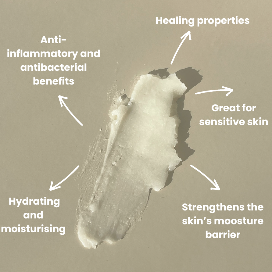 Smeared Organic Baby Balm product on a neutral surface with arrows demonstrating the benefits of the product.