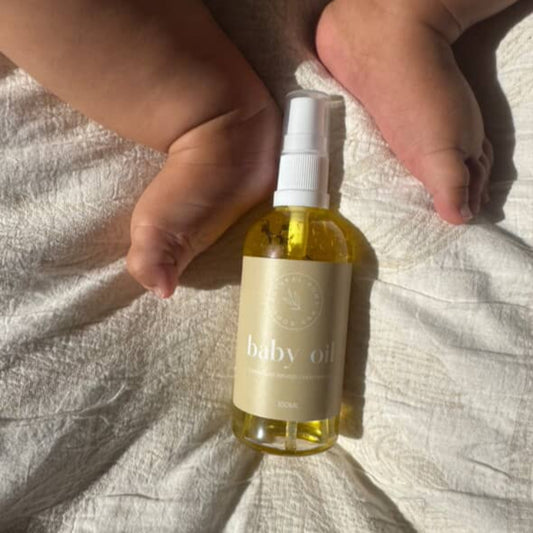 The organic baby oil centred with some baby feet on the top of the frame.