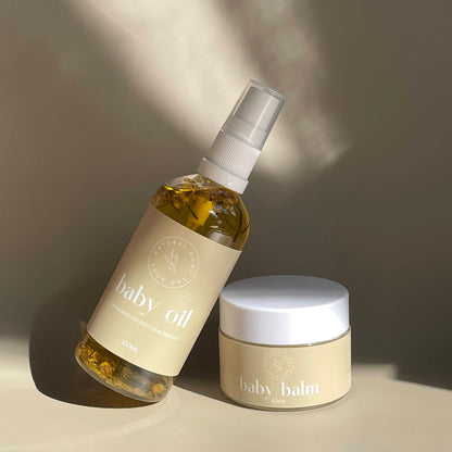 Baby oil bottle and balm jar on a neutral background